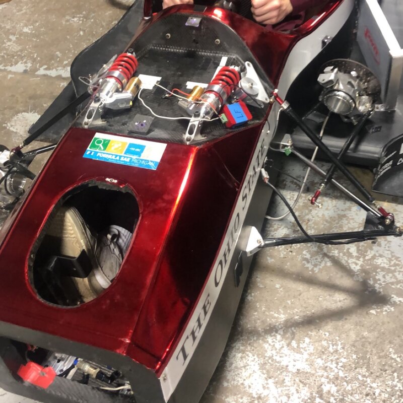 Formula SAE car with carbon bodywork showing pushrod suspension and dampers