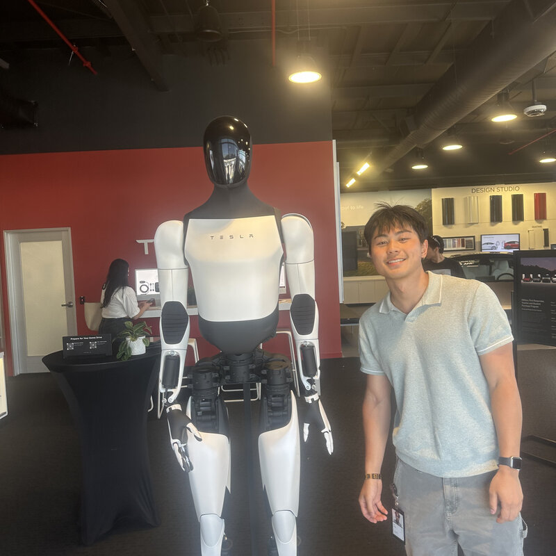 Jay Chung standing beside a Tesla Optimus humanoid robot